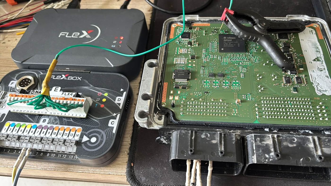 Engine ECU opened on the bench with a Flex programmer connected to an Infineon TriCore processor