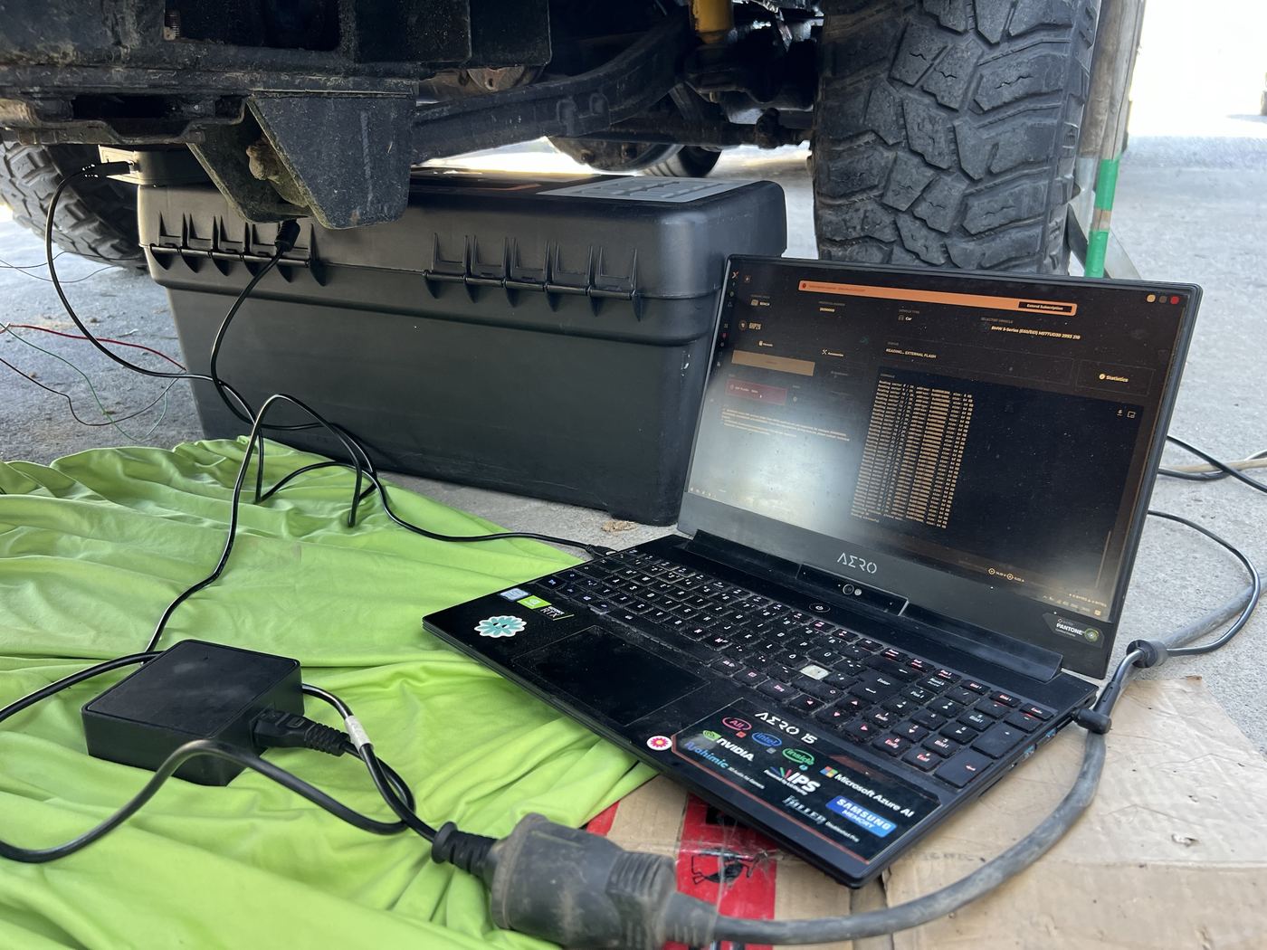 Laptop on the ground reading a gearbox control unit under a 4x4
